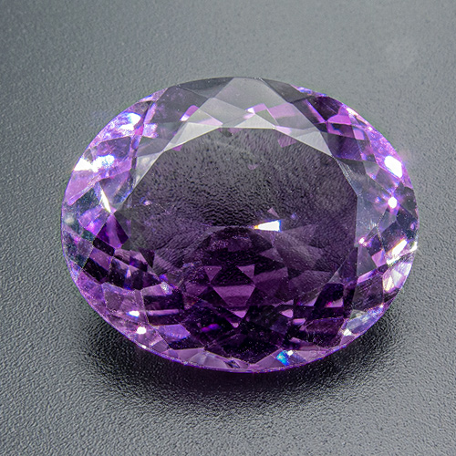 Amethyst from Zambia. 20.62 Carat. Shallow pavilion, looks heavier (and more expensive)  than it is. Small inclusion near culet (tip), beautiful colour, slightly zoned - cheap!