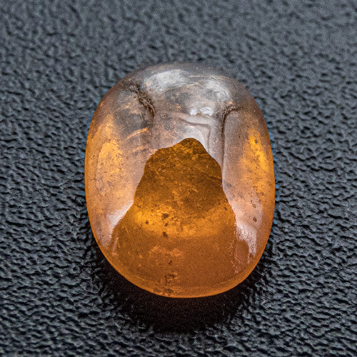 Mandarin garnet from Namibia. 0.56 Carat. Cabochon Oval, very, very distinct inclusions