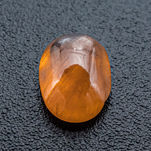 Mandarin Garnet from Namibia. 0.59 Carat. Cabochon Oval, very, very distinct inclusions