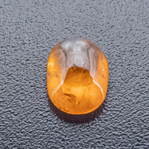 Mandarin Granat aus Namibia. 0,52 Karat. Cabochon Oval, sehr, sehr deutliche Einschlüsse