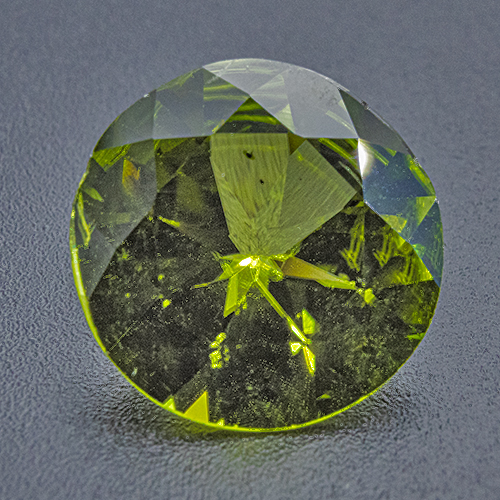 Peridot from Myanmar. 5.23 Carat. 2nd quality, slightly off round cut can be hidden in bezel setting