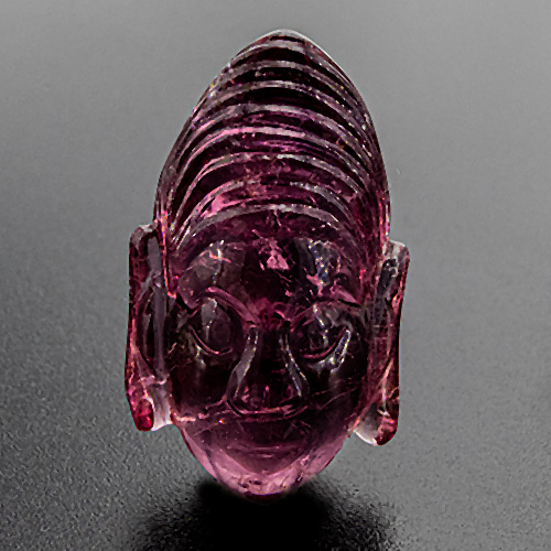 Tourmaline (Rubellite) from India. 1 Piece. Unusual, iconographically interesting Khmer style buddha head. Handcarved in India in the 1980ies. Weight: 21.16cts