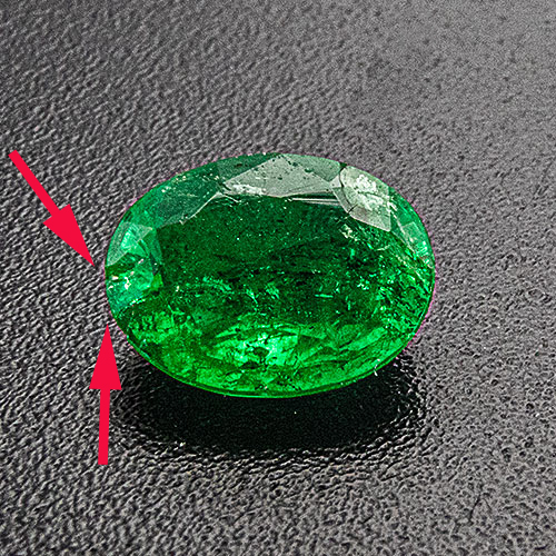 Emerald from Brazil. 0.79 Carat. Shows two small chips at girdle which cannot be fully hidden in a bezel setting