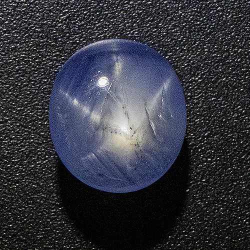 Star Sapphire from Sri Lanka. 3.25 Carat. Very good colour and star. Surface reaching natural cracks are not nearly as prominent as on this strongly enlarged photo.