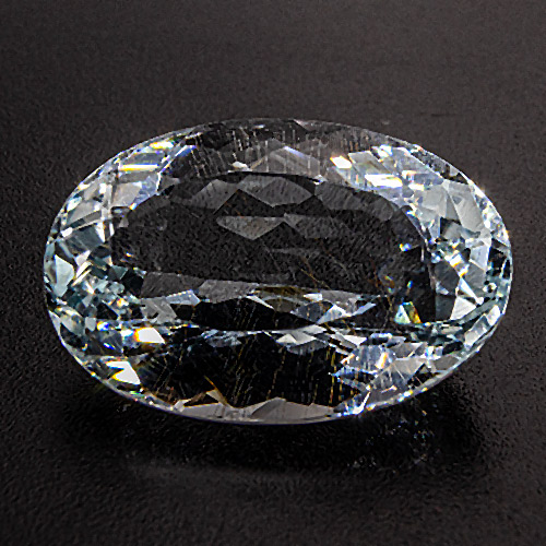Natural Blue Topaz from Brazil. 13.54 Carat. Sports several golden yellow, needle-shaped limonite inclusions