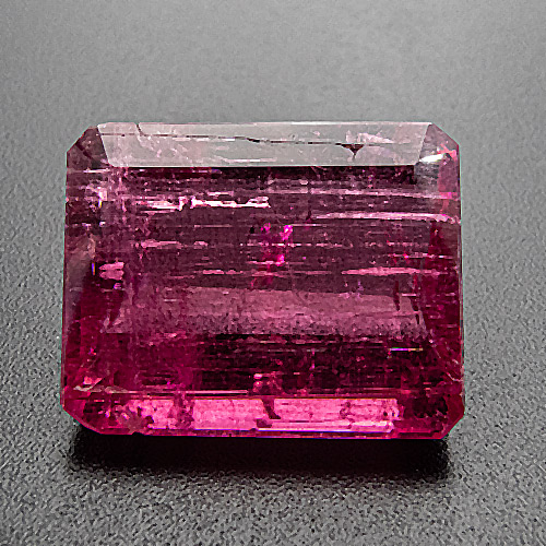 Tourmaline (Rubellite) from Brazil. 11.62 Carat. The fine orangish pink colour, large size and, last but not least, low price made us buy this highly interesting gem, despite some surface-reaching inclusions, which, to the naked eye, are not nearly as prominent as on the enlarged photo.